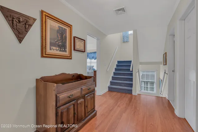a living room with a bed furniture and paintings on the wall
