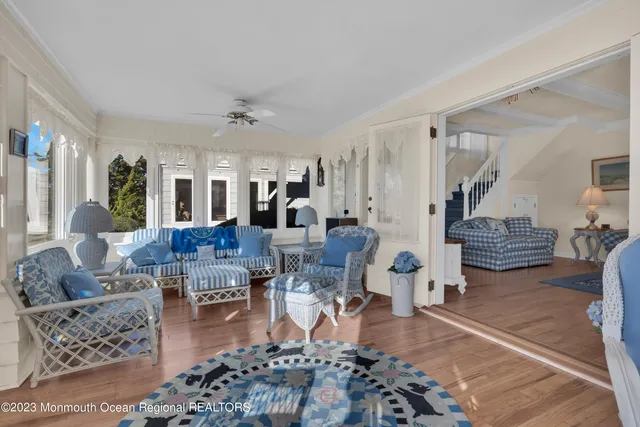 a living room with lots of furniture a rug and a chandelier