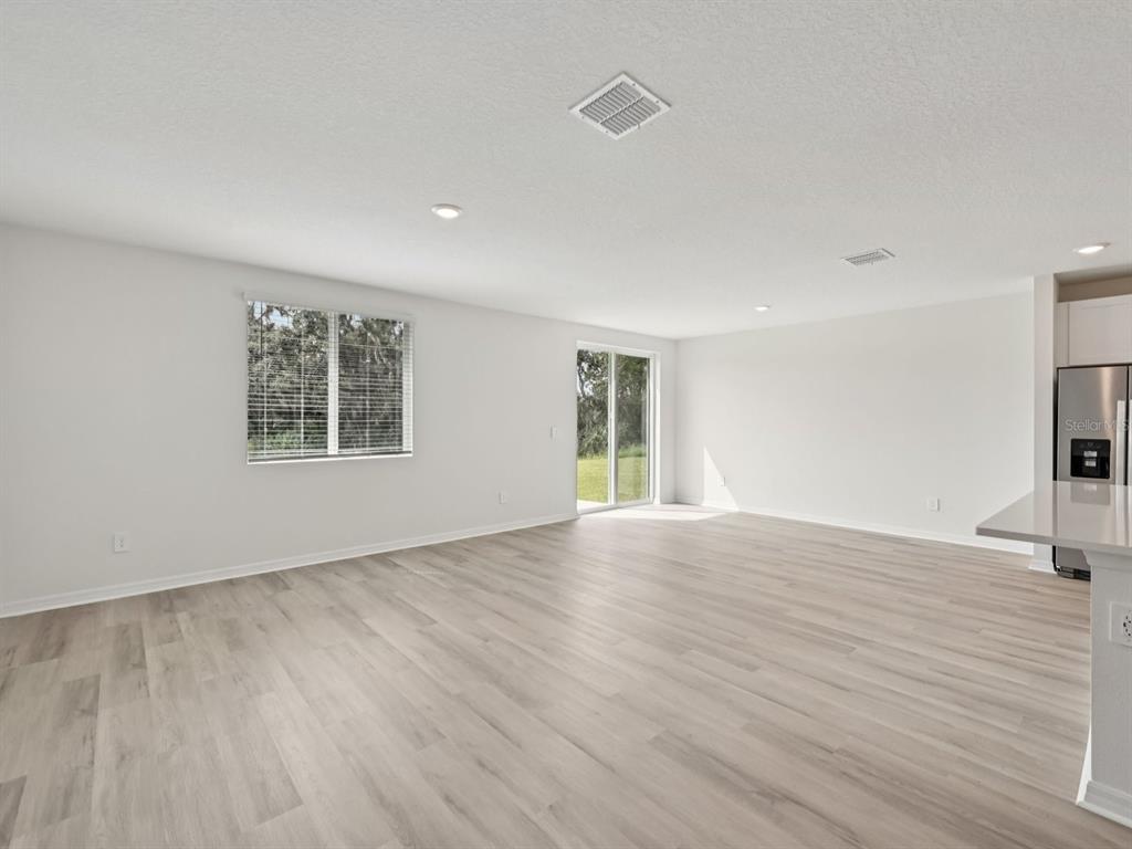 7628 Satterfield Terrace Parrish, FL 34219 - Photo 6 of 25 a view of an empty room with a window and wooden floor