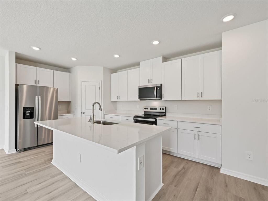 7628 Satterfield Terrace Parrish, FL 34219 - Photo 8 of 25 a kitchen with stainless steel appliances a refrigerator sink and microwave
