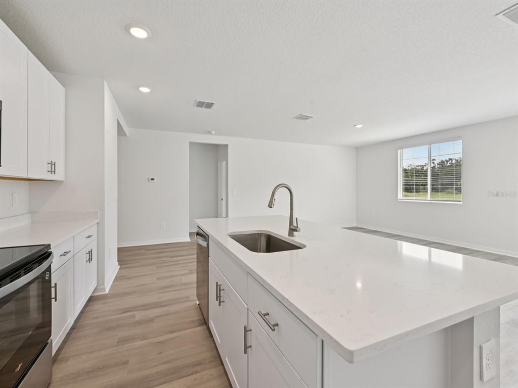 7628 Satterfield Terrace Parrish, FL 34219 - Photo 10 of 25 a large white kitchen with sink and cabinets