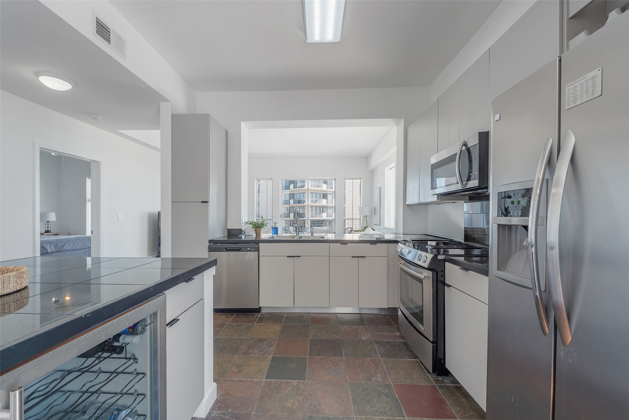 3505 Sage Road, Unit 2210 Houston, TX 77056 - Photo 9 of 40 A bright, open kitchen equipped with stainless steel appliances—including a built-in drink cooler—and abundant storage, combine style and functionality.