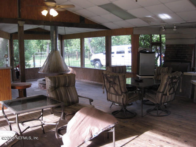 4026 Mustang Road Middleburg, FL 32068 - Photo 14 of 32 a living room with furniture a flat screen tv and floor to ceiling window
