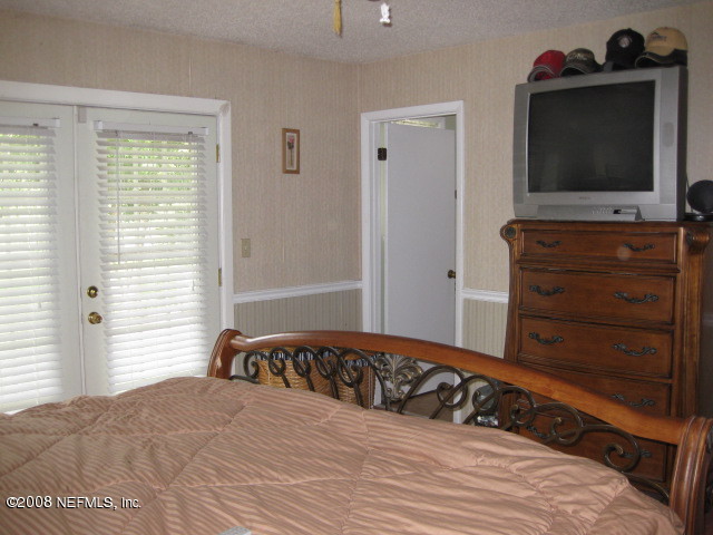 4026 Mustang Road Middleburg, FL 32068 - Photo 16 of 32 a bedroom with a bed and a flat screen tv