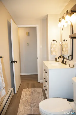 a view of an empty room with wooden floor and closet