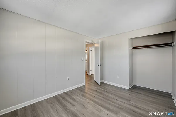 an empty room with wooden floor and entrance