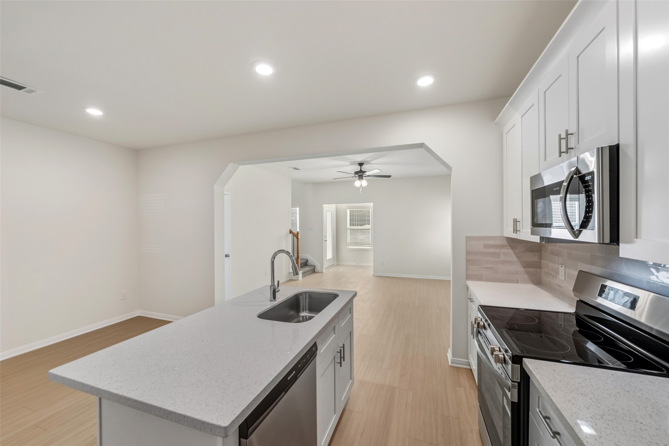 716 West Dallas Street Conroe, TX 77301 - Photo 14 of 24 a kitchen with a sink dishwasher a stove and a refrigerator with wooden floor
