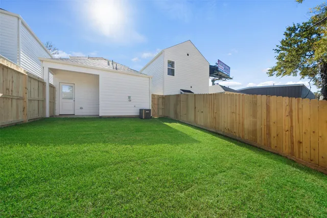 a view of a backyard with potted plants and wooden fence