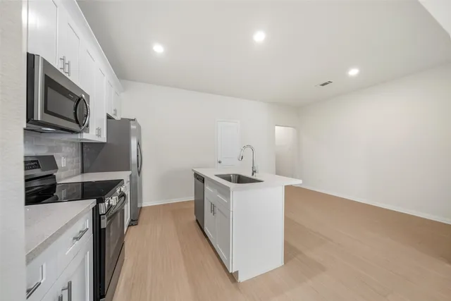 a kitchen with stainless steel appliances a sink stove and cabinets