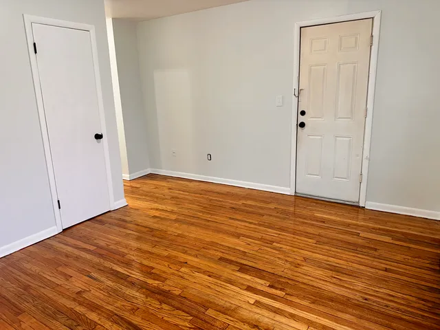 a view of an empty room with wooden floor