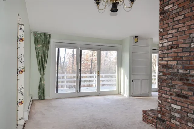 a view of an empty room with a fireplace and a window