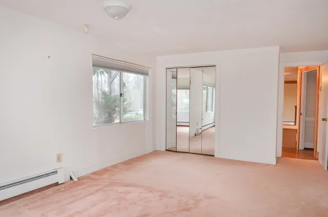 an empty room with windows and closet