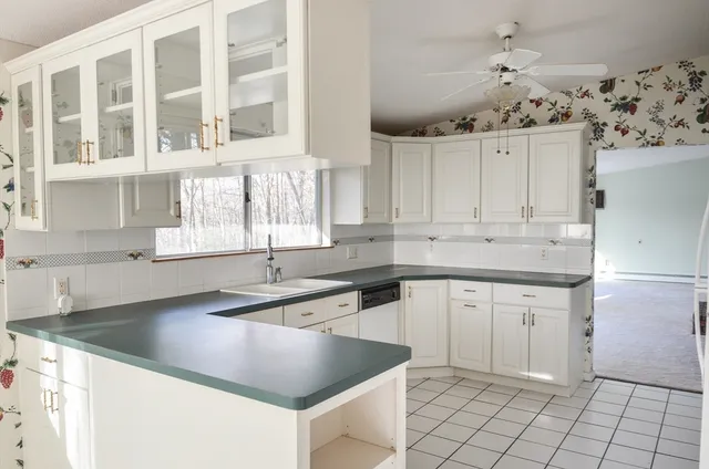 a kitchen with stainless steel appliances granite countertop a sink and dishwasher with white cabinets