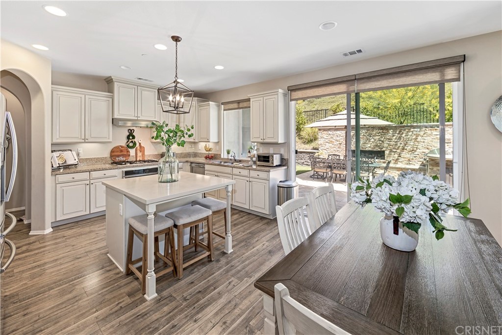 28504 Farrier Drive Valencia, CA 91354 - Photo 14 of 45 a kitchen with a table chairs stove and wooden floor
