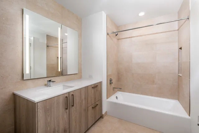 a bathroom with a bathtub a shower a sink and a mirror