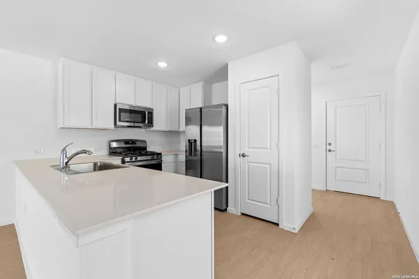 a kitchen with a refrigerator a sink and cabinets