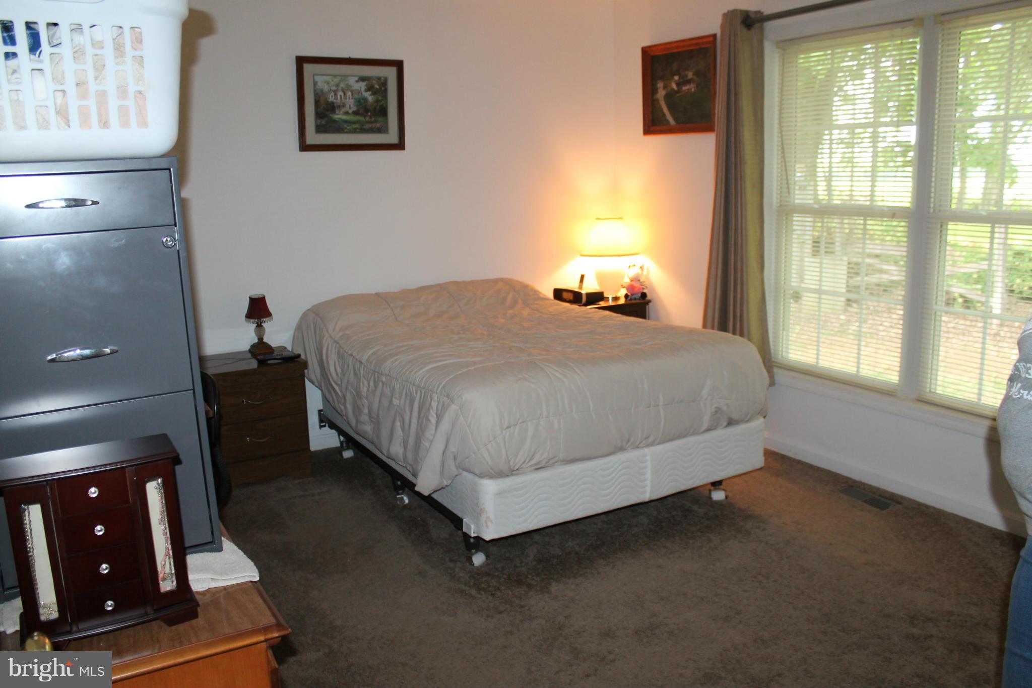 209 Robelei Drive Ranson, WV 25438 - Photo 17 of 30 a bed sitting in a bedroom next to a window