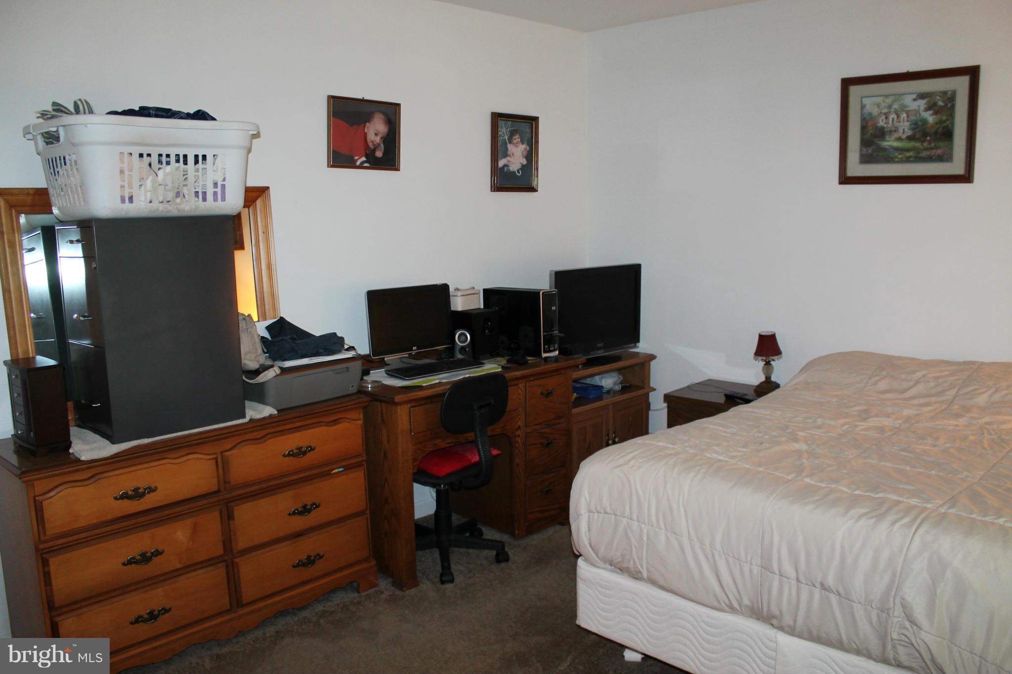 209 Robelei Drive Ranson, WV 25438 - Photo 18 of 30 a bedroom with a bed and a flat tv screen on dresser