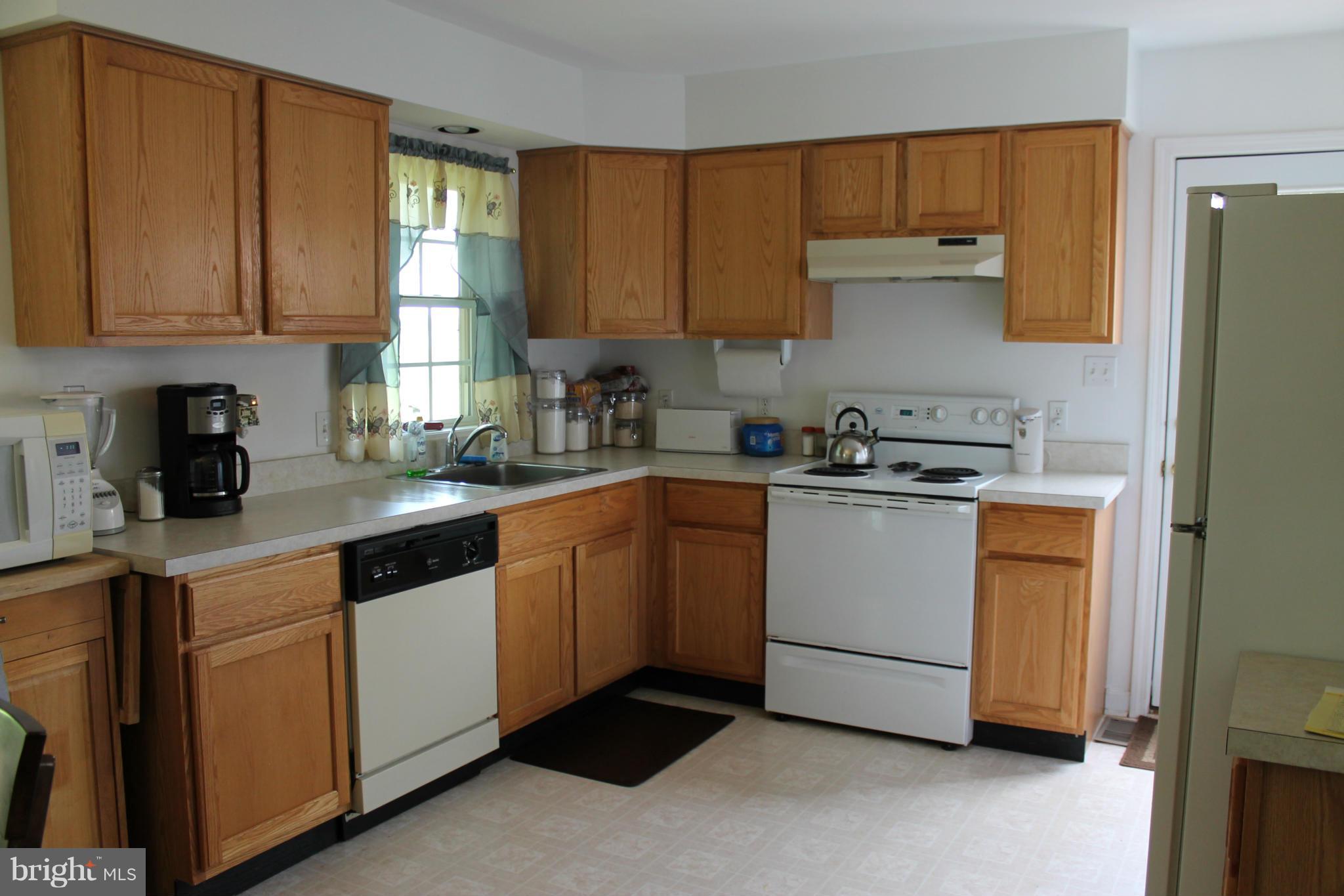 209 Robelei Drive Ranson, WV 25438 - Photo 7 of 30 a kitchen with cabinets appliances a sink and a window