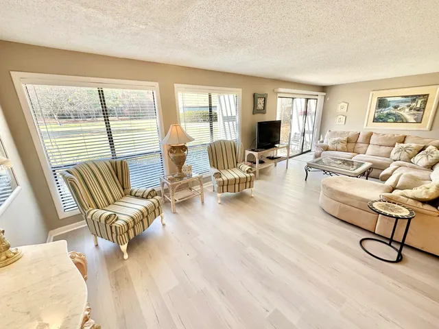 a living room with furniture and a flat screen tv with wooden floor