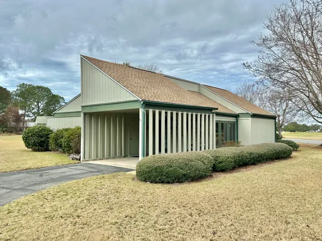 a front view of house with yard and trees around