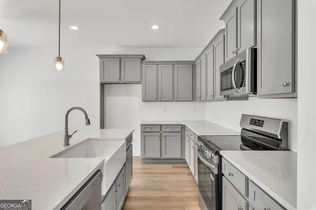 a large kitchen with kitchen island a stove a sink a center island and wooden floor
