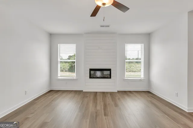 an empty room with a window and wooden floor