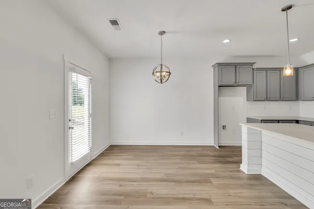 a view of kitchen with wooden floor appliances and window