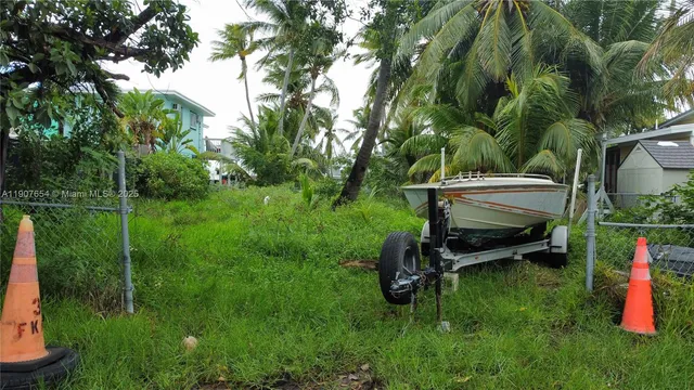 a backyard of a house with table and chairs a fire pit