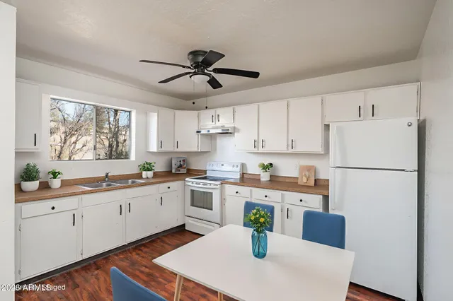 a kitchen with stainless steel appliances a refrigerator sink and white cabinets