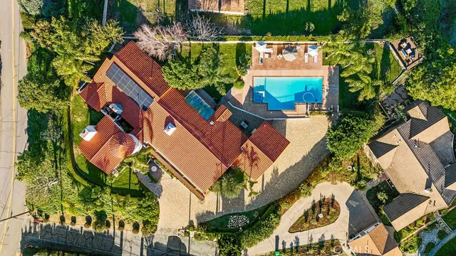 an aerial view of a house with a yard and potted plants