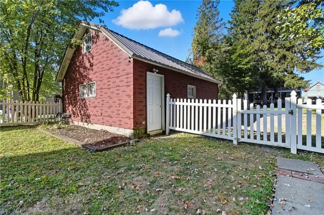 a view of a house with a small yard and wooden fence