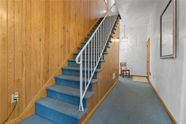a view of staircase with lots of frames on wall and wooden floor
