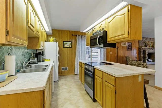 a kitchen with stainless steel appliances granite countertop a sink stove and refrigerator
