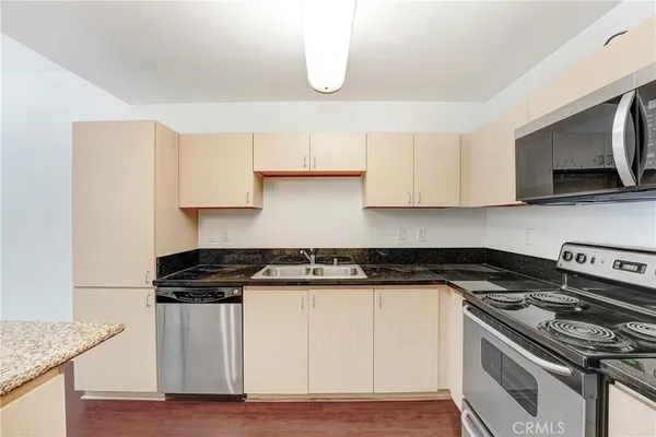 a kitchen with stainless steel appliances white cabinets and a stove top oven