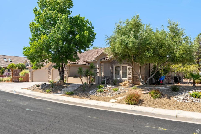 1609 East 10 S Street St. George, UT 84790 - Photo 3 of 68 Exterior featuring a tile roof, stucco finish, stone accents, mature trees, and a two-car garage