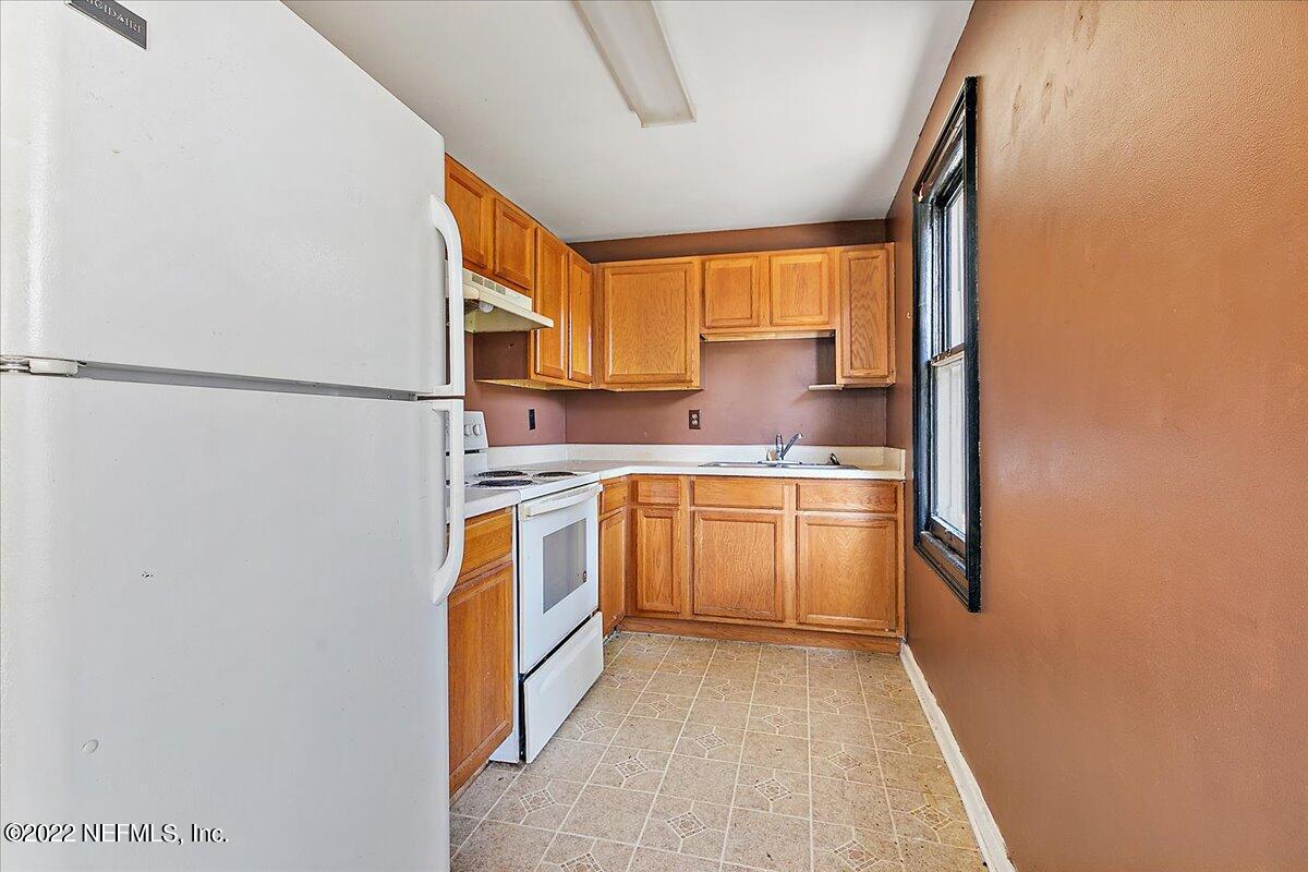 3404 St Augustine Road Jacksonville, FL 32207 - Photo 13 of 16 a kitchen with a refrigerator sink and cabinets