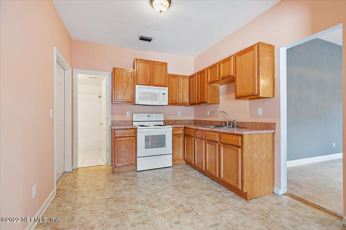 3404 St Augustine Road Jacksonville, FL 32207 - Photo 4 of 16 a kitchen with stainless steel appliances granite countertop a stove a sink and a refrigerator