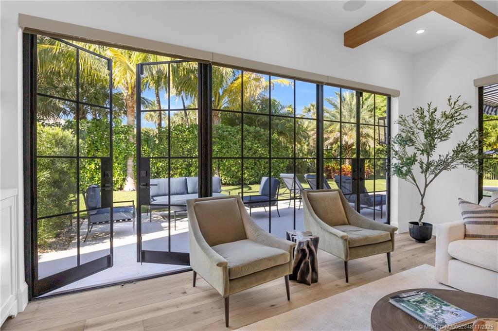 44 South Beach Road Hobe Sound, FL 33455 - Photo 13 of 73 a living room with furniture and a floor to ceiling window