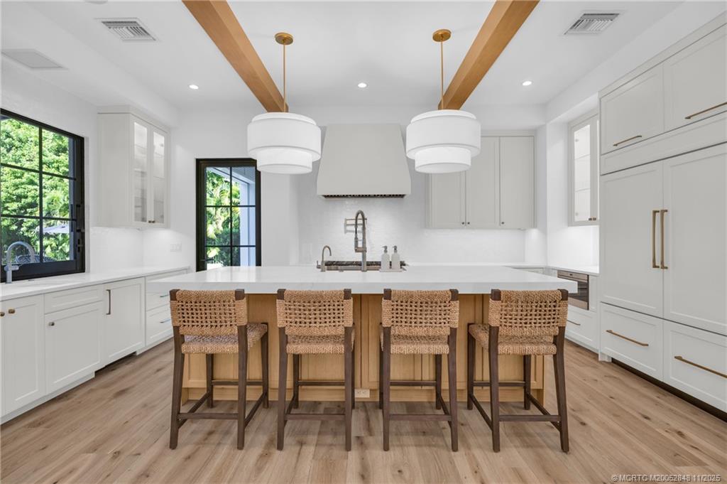 44 South Beach Road Hobe Sound, FL 33455 - Photo 16 of 73 a kitchen with stainless steel appliances a dining table chairs sink and wooden floor