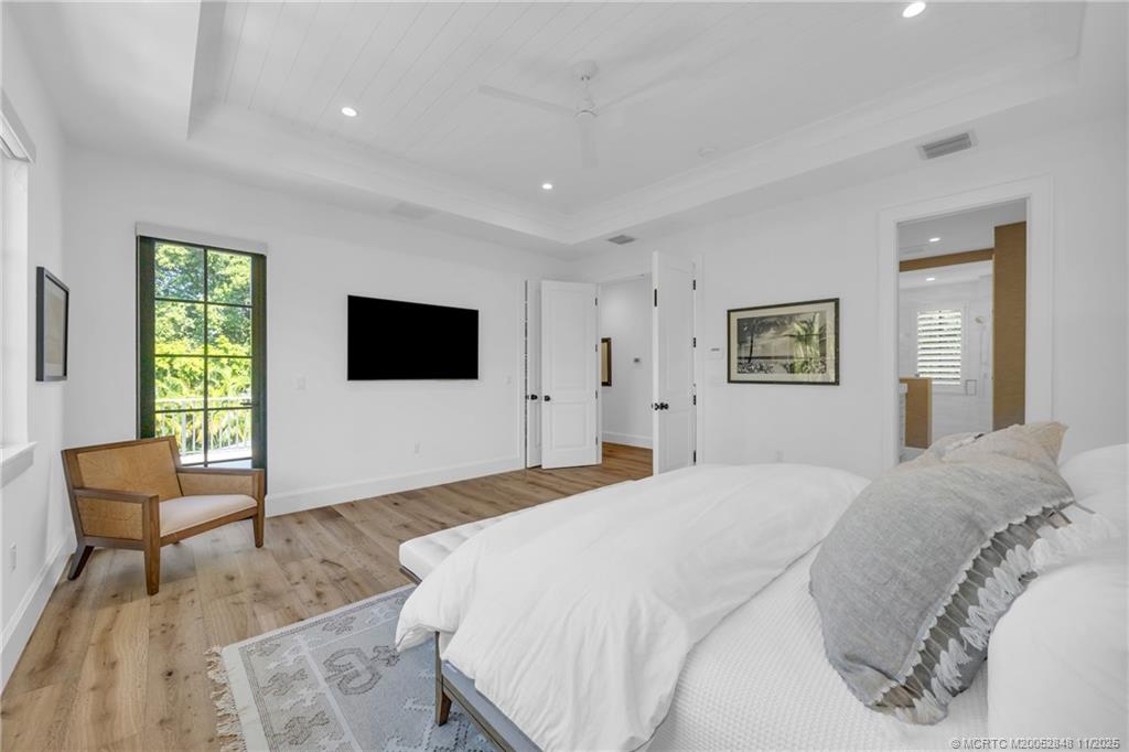 44 South Beach Road Hobe Sound, FL 33455 - Photo 40 of 73 a spacious bedroom with a bed and a flat screen tv