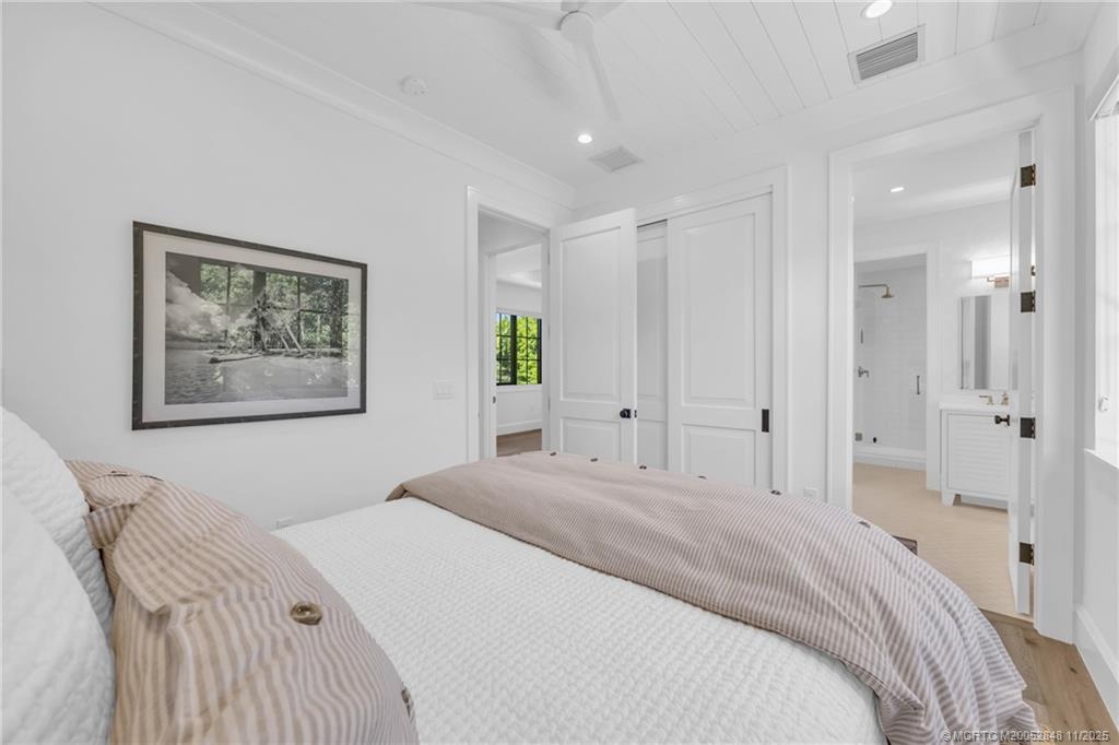 44 South Beach Road Hobe Sound, FL 33455 - Photo 55 of 73 a bedroom with a large bed and a chandelier