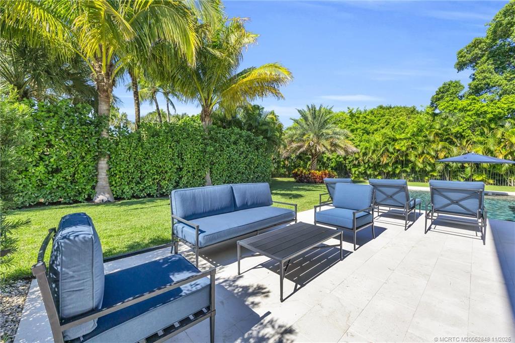 44 South Beach Road Hobe Sound, FL 33455 - Photo 61 of 73 a view of a patio with a table and chairs under an umbrella