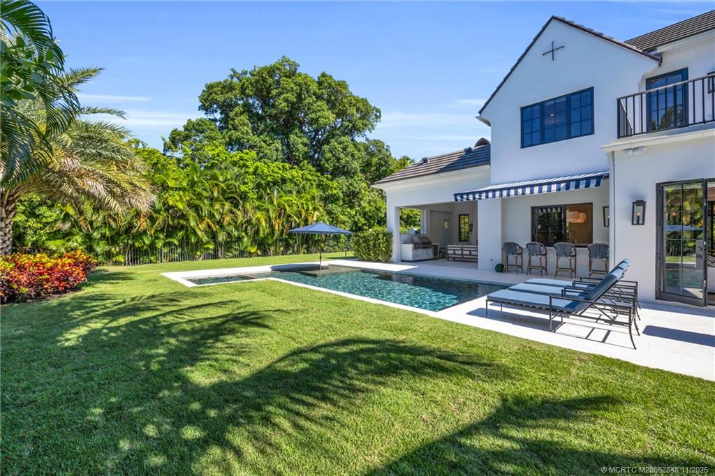 44 South Beach Road Hobe Sound, FL 33455 - Photo 65 of 73 a view of swimming pool with lawn chairs and plants