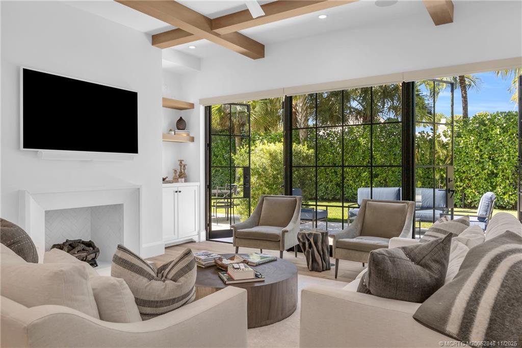 44 South Beach Road Hobe Sound, FL 33455 - Photo 10 of 73 a living room with furniture a flat screen tv and a floor to ceiling window