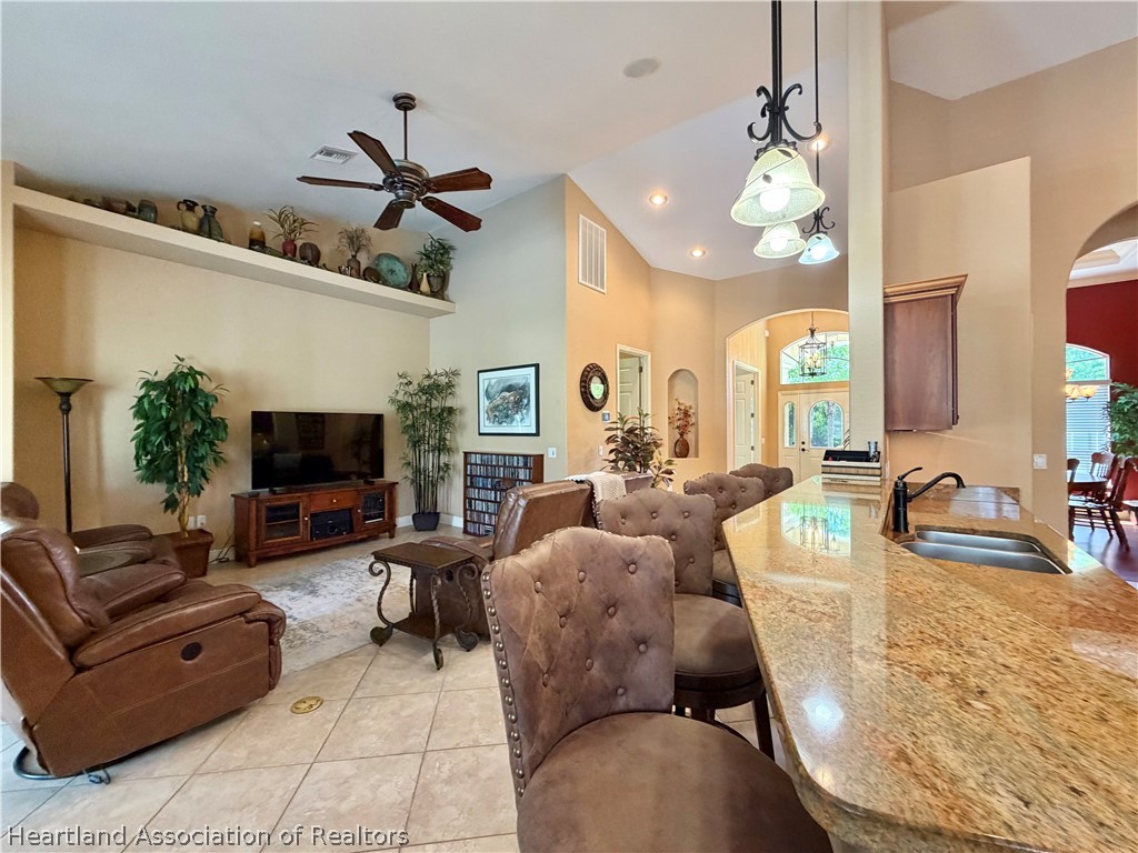 6032 Elm Road Sebring, FL 33875 - Photo 11 of 47 a living room with furniture a ceiling fan and a flat screen tv