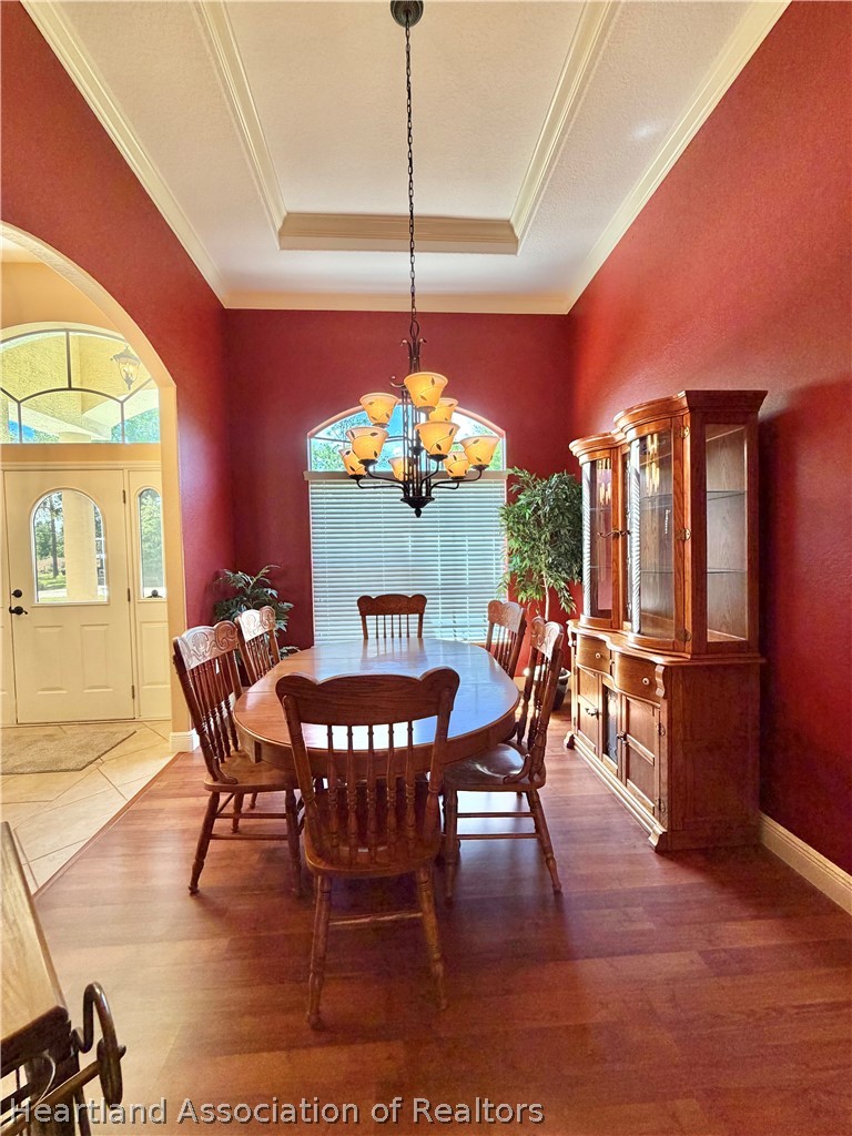6032 Elm Road Sebring, FL 33875 - Photo 14 of 47 a dining room with furniture a chandelier and wooden floor