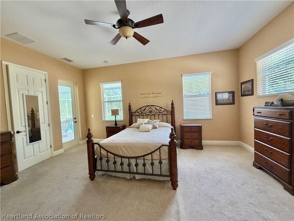 6032 Elm Road Sebring, FL 33875 - Photo 17 of 47 a bedroom with a bed and a chandelier