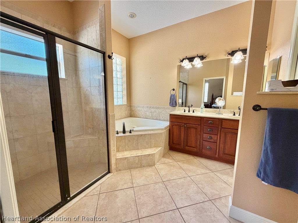 6032 Elm Road Sebring, FL 33875 - Photo 19 of 47 a bathroom with a bathtub a sink a mirror and a shower