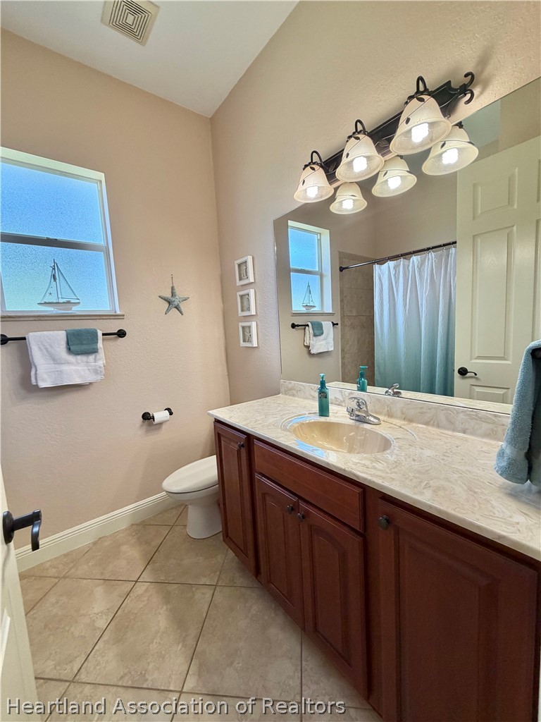 6032 Elm Road Sebring, FL 33875 - Photo 20 of 47 a bathroom with a sink a toilet and a mirror